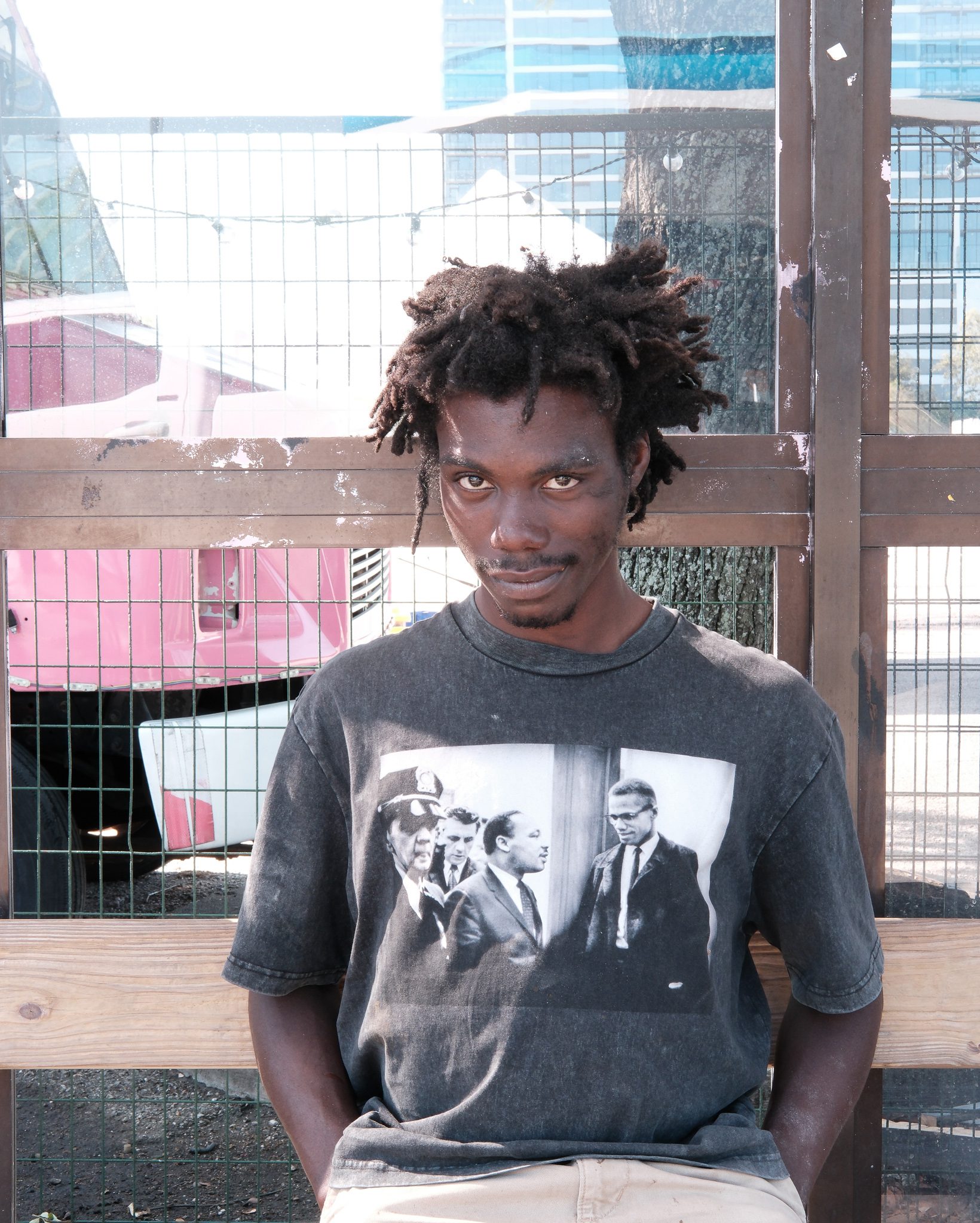 Man with black shirt sitting on a bench