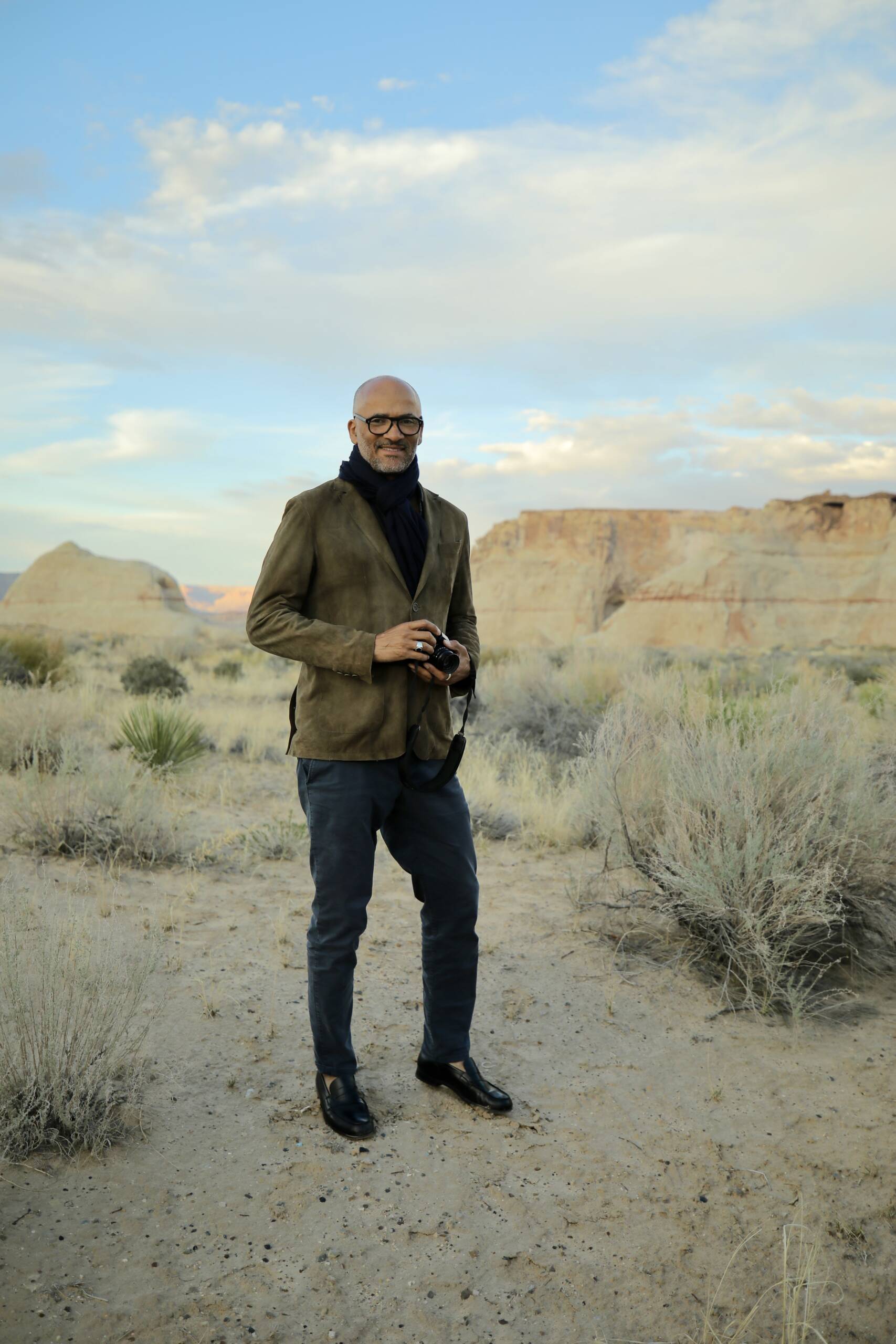 A man with a camera with big sky behind