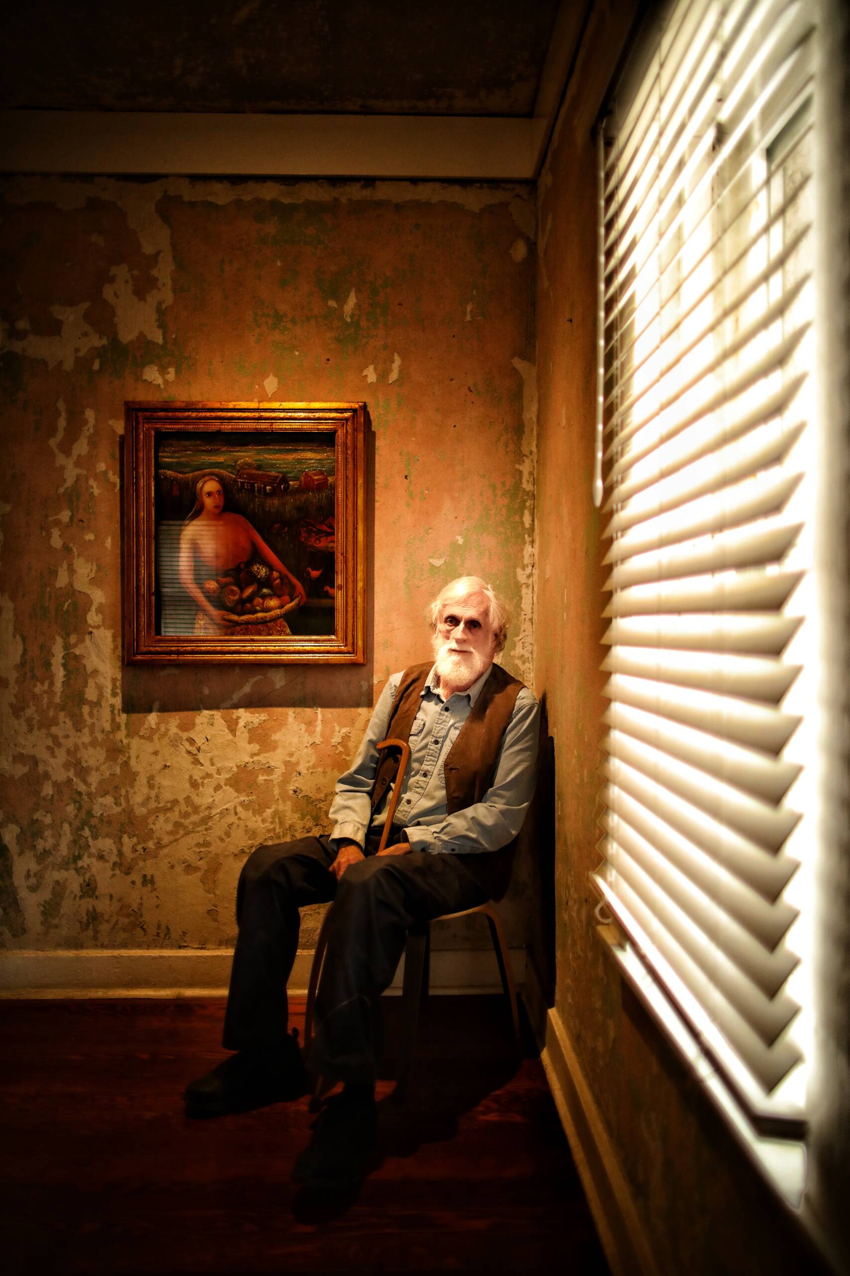 An old man by the window, with a picture next to him